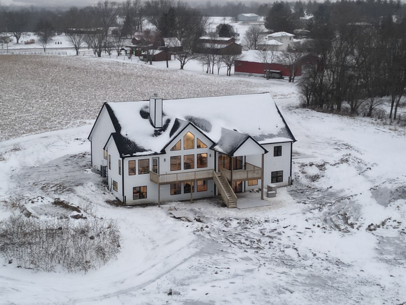 Aerial view of a custom acreage home with a walkout lower level and prow window wall, built in Central Iowa