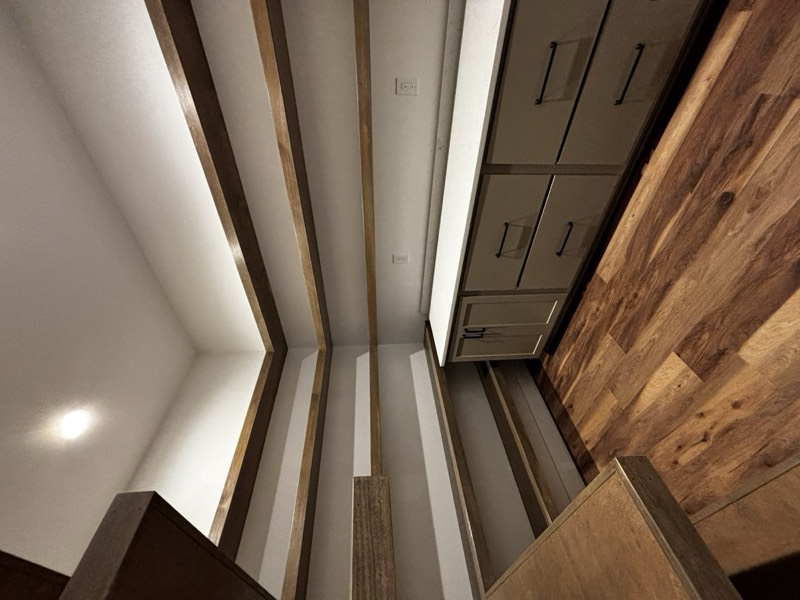 Walk-in pantry with solid timber shelves wrapping three walls above quartz counters